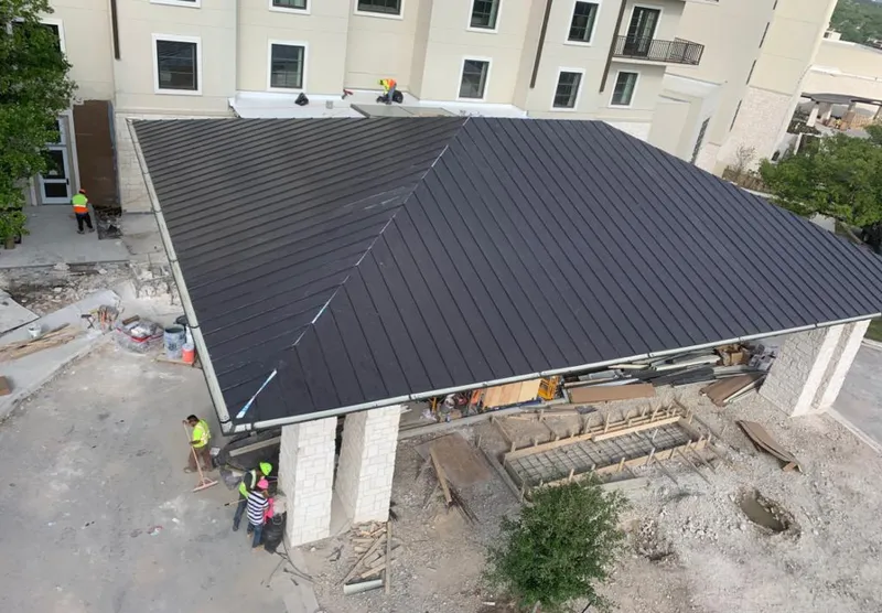 Metal roofing installation team working on a commercial building in Southgate